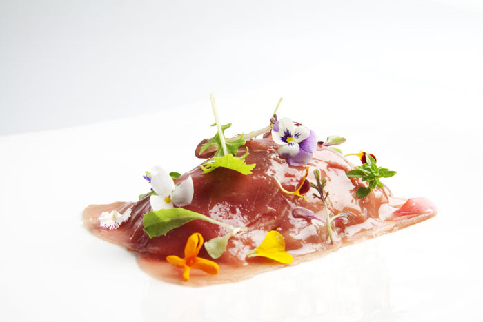 Un plato decorado con flores naturales de Susi Díaz, restaurante La Finca.